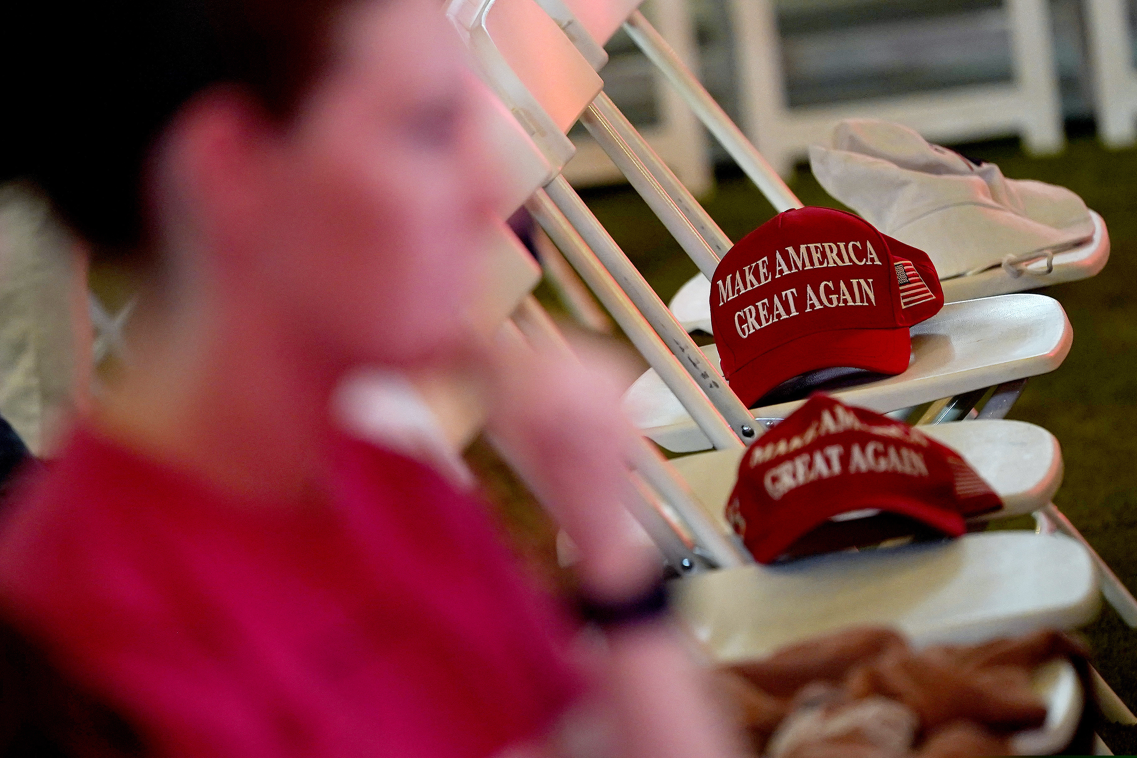 MAGA hats sit on empty seats during an election watch party, Tuesday, Nov. 3, 2020, in Chandler, Ariz. (AP Photo/Matt York)