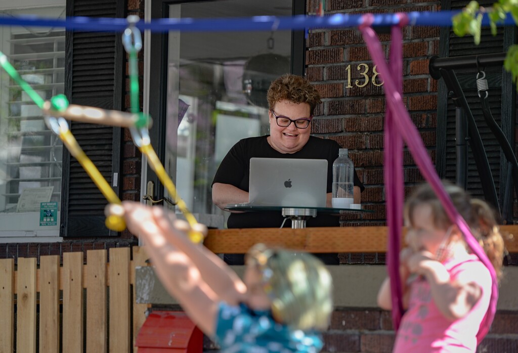 (Francisco Kjolseth  |  The Salt Lake Tribune) Beth Jennings, a University of Utah assistant librarian works from the front porch of their Salt Lake City home on Tuesday, April 21, 2020 as her daughters play out front. When schools began closing due to the coronavirus, hundreds of activities began popping up to give parents something to do with their kids while they are stuck at home. For many, finding and navigating through those tools has become a headache and a deterrent. Jennings was one of those parents, so she started compiling and organizing some of the best free links in one place.