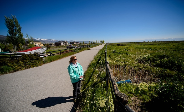 Trent Nelson | The Salt Lake Tribune
Christine Mikkelsen looks out into the quiet open space behind her Farmington home that may soon be occupied by the West Davis Corridor highway, Thursday May 4, 2017. Mikkelsen and her husband moved into their home six years ago when they were told they would never lose their view thanks to the Buffalo Ranch that would prevent development from blocking the sweeping vista of the Great Salt Lake and Antelope Island. Later, when they learned about the West Davis Corridor, a roughly 20-mile stretch of new freeway planned in northern Utah, with a $600 million-plus price tag, Mikkelsen became heavily involved in the Save Farmington group that has opposed the project. “Most people who bought out here bought for the view, for the quiet and for the country feel,” Mikkelsen says. Now they will live with the noise and air pollution and a close up view of a freeway in their backyards and she says all state taxpayers will live with the bill of a very costly project.