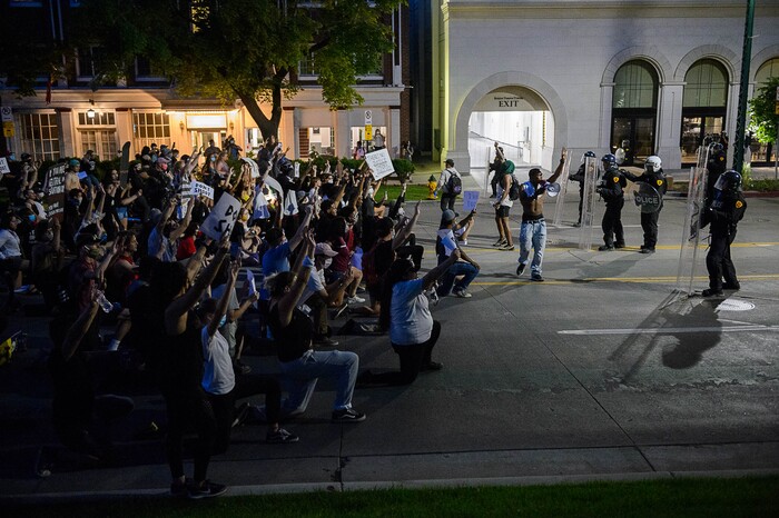 (Trent Nelson  |  The Salt Lake Tribune) Protesters kneel in front of a police line on South Temple in Salt Lake City on Monday, June 1, 2020.
