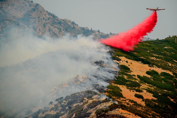 (Trent Nelson | The Salt Lake Tribune)  A plane makes a drop on a fire at the mouth of Weber Canyon, Tuesday September 5, 2017.