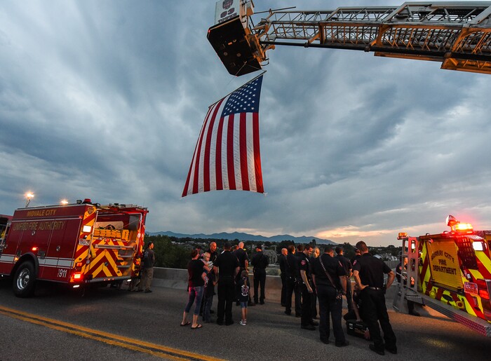 (Francisco Kjolseth  |  The Salt Lake Tribune)  The body of Utah firefighter Matt Burchett, 42, who died fighting a wildfire in California is honored by a firefighter detail along Murray Parkway as his body is returned home, traveling along I-215 after being flown in to the Utah Air National Guard in Salt Lake City on Wed. Aug. 15, 2018. The remains of the Draper battalion chief were transported to Jenkins-Soffe Mortuary in South Jordan.