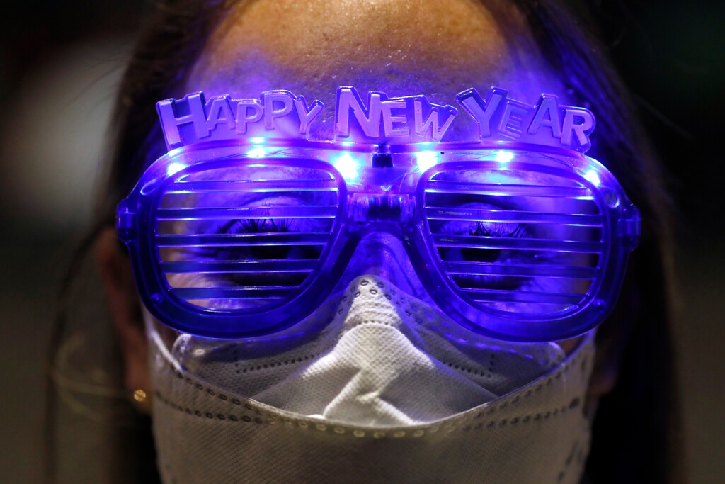 (Rebecca Blackwell | AP photo)
Alejandra Paiz, a tourist from Guatemala who is visiting Mexico for the holidays with a friend and their respective sons, wears festive glasses as the group marks New Year's Eve at the Angel of Independence monument in Mexico City, just after midnight on Friday, Jan. 1, 2021. Although Mexico City cancelled its annual New Year's celebration to curb the spread of the COVID-19 pandemic, dozens of people came out in small groups to mark midnight with selfies and video calls from the iconic city landmark.