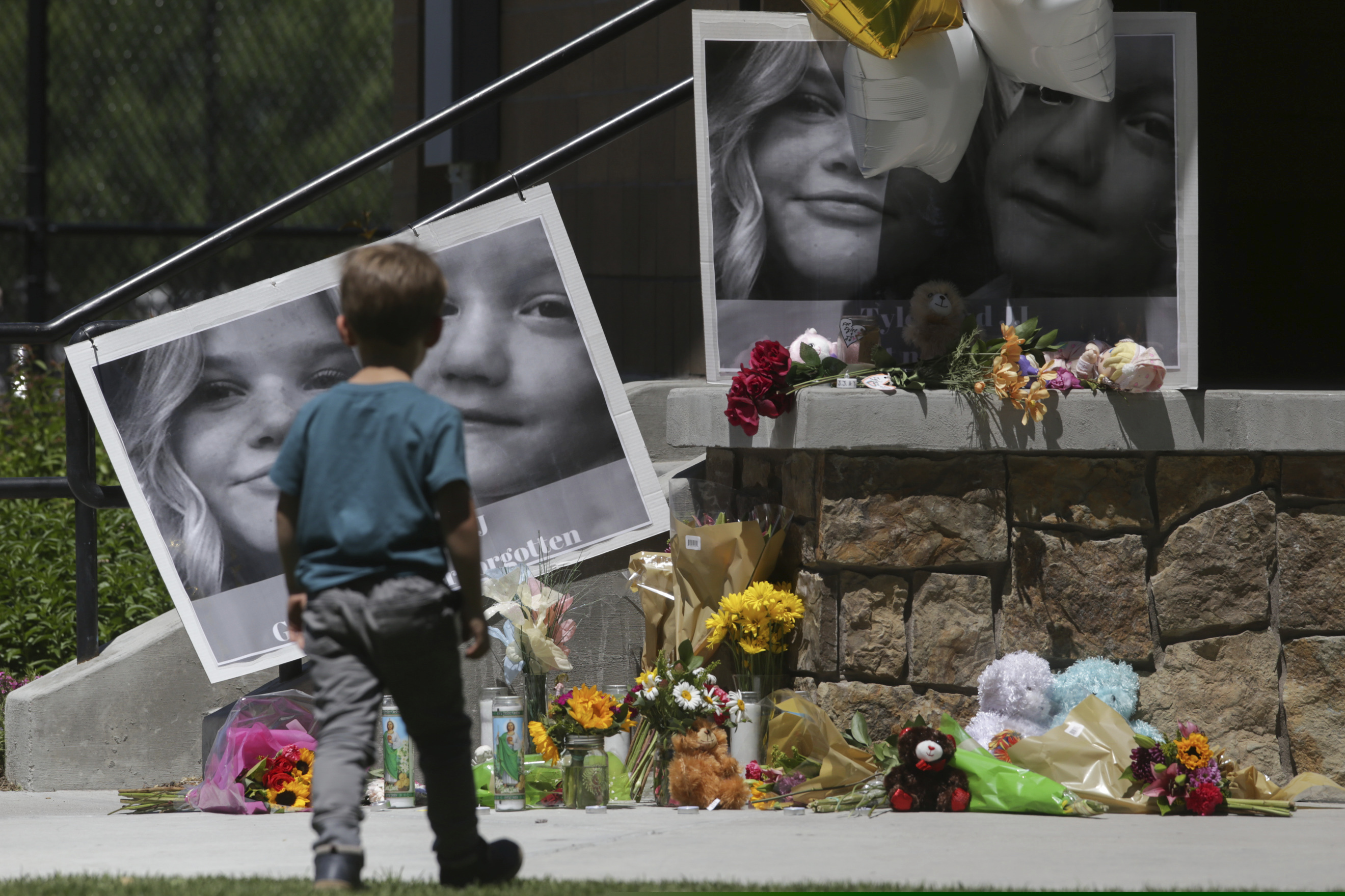 A boy checks out a memorial for Tylee Ryan, 17, and Joshua "JJ" Vallow, 7, at Porter Park in Rexburg, Idaho on Thursday, June 11, 2020. (John Roark/The Idaho Post-Register via AP)