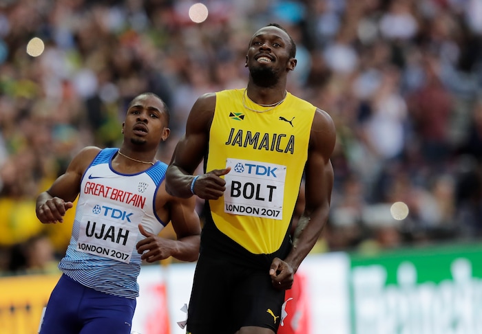 Jamaica's Usain Bolt and Britain's Chijindu Ujah, left, react after finishing a Men's 100 meters semifinal during the World Athletics Championships in London Saturday, Aug. 5, 2017. (AP Photo/Tim Ireland)