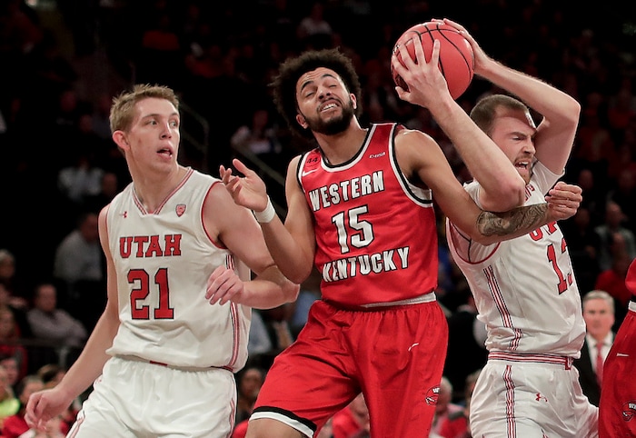 Utah forward David Collette (13) pulls down a rebound against Western Kentucky guard Darius Thompson (15) as Utah forward Tyler Rawson (21) watches during the second half of an NCAA college basketball game during the semifinals of the NIT, Tuesday, March 27, 2018, in New York. Utah won 69-64. (AP Photo/Julie Jacobson)