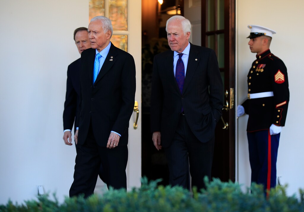Senate Finance Committee Chairman Sen. Orrin Hatch, R-Utah, and members Sen. John Cornyn, R-Texas and Sen. Patrick Toomey, R-Pa., back left, walk from the the West Wing to speak to reporters after a meeting with President Donald Trump at the White House in Washington, Monday, Nov. 27, 2017. (AP Photo/Manuel Balce Ceneta)