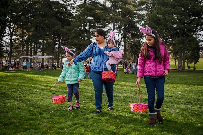 (Nicole Boliaux | For The Tribune) Adriana Rogers, middle, holds her niece Sophia and walks with Ana, right, and Marina, left, during the annual Easter egg hunt put on by A Kid's Place Dentistry in Liberty Park in Salt Lake City on Saturday, March 31, 2018.