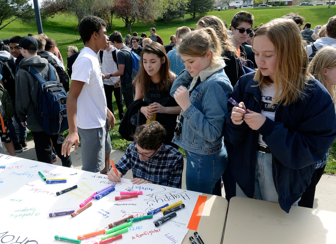 (Al Hartmann  |  The Salt Lake Tribune) 	Highland High School students sign a poster that said "When I grow up I want to be...."  Over one hundred students at Highland High School staged a walkout Friday April 20, 2018 in honor of the anniversary of the Columbine High School massacre. Demonstrators walked from the school to Sugar House Park where they made posters, wrote letters to their congressmen and listened to speakers. 