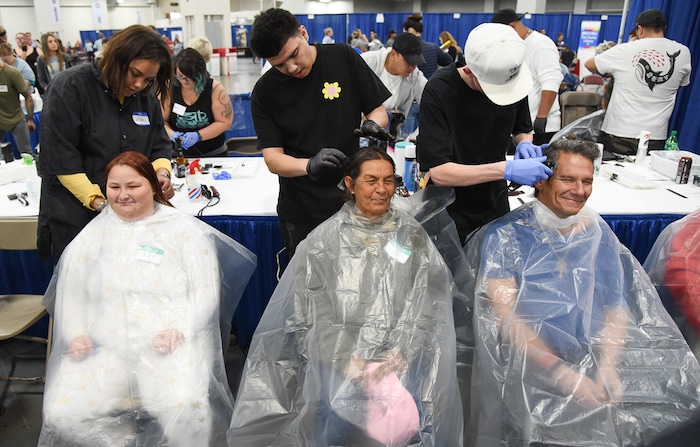 (Francisco Kjolseth  |  The Salt Lake Tribune)  Riley Hunter, Ina Mitchell and Shane Rudy, from left, get haircuts from Caitlyn Clarke, Santiago Diaz and Adley Prescott during Salt Lake CityÕs second annual Project Homeless Connect that took place at the Salt Palace Convention Center on Friday, Oct. 12, 2018. More than 800 community volunteers and 90 service providers connect those in need with more than 200 services.