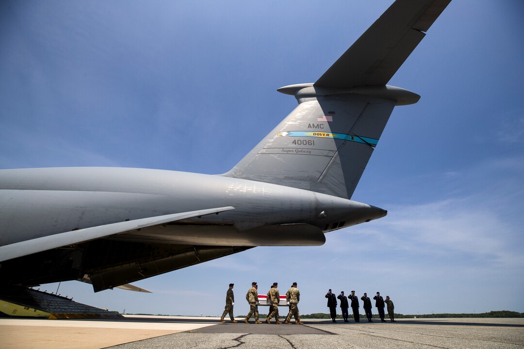 (Alex Brandon  |  AP Photo) Officers salute as an Army carry team moves a transfer case containing the remains of U.S. Army Sgt. 1st Class Elliott J. Robbins, at Dover Air Force Base, Del., Tuesday, July 2, 2019. According to the Department of Defense, Robbins, of Ogden, Utah, assigned to the 10th Special Forces Group died while supporting Operation Freedom's Sentinel.