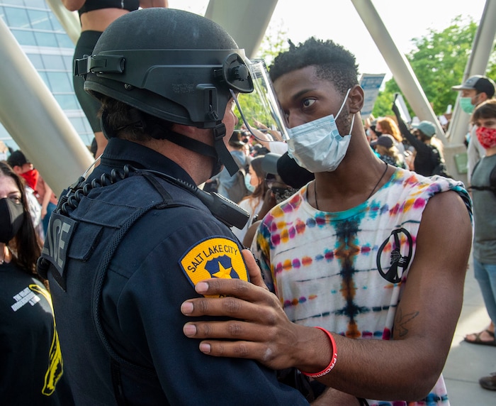 (Rick Egan  |  The Salt Lake Tribune) Henry Kemp hugs a Salt Lake City Police officer at the Public Safety Building during a demonstration on Monday, June 1, 2020.