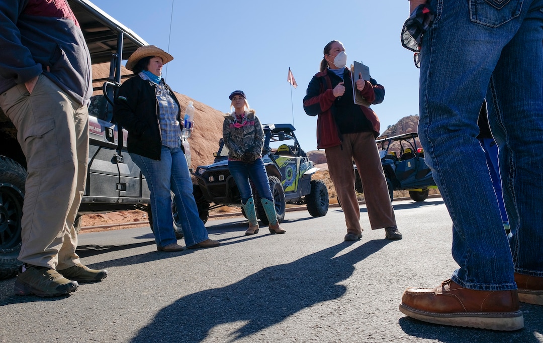 (Leah Hogsten | The Salt Lake Tribune)  Moab residents Cricket Green, left, and daughter Amasie Willison, center, with Moab Cowboy Country Offroad Adventures, listen as Andrea Brand, the director of the Sand Flats Recreation Area, right, talks with other volunteers providing trail resortation and repairs on the Hell's Revenge trail, Feb. 20, 2021.
