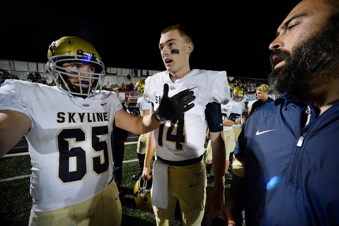 (Scott Sommerdorf   |  The Salt Lake Tribune)   Skyline DL/C Dax Lowe, left, talks with starting QB Tommy McGrath, center and RB coach Aryah Fard during the last minute of the game as Skyline beat Brighton 42-28, Friday, September 15, 2017.