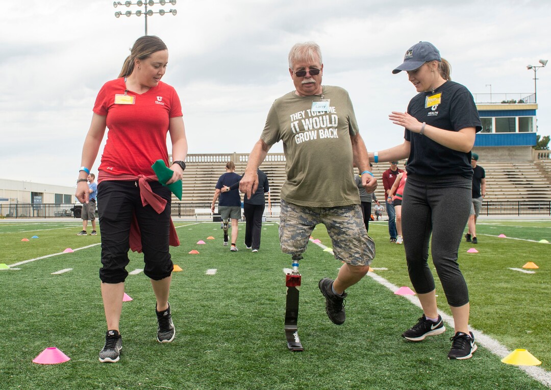 (Rick Egan  |  The Salt Lake Tribune)       Kristen Black-Bain assists Larry Christensen, along with Victoria Vega, from the University of Utah, during the fourth annual Utah Adaptive Mobility Clinic at Skyline High school. The clinic allows anyone with "lower extremity limb loss or limb difference" or amputees without legs, to practice walking and running. Saturday, June 1, 2019.