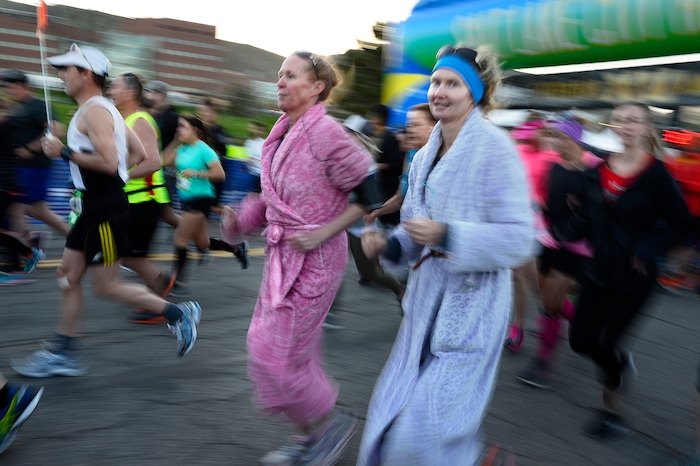 (Scott Sommerdorf | The Salt Lake Tribune)Two women in bath robes leave the starting line of the Salt Lake City marathon, Saturday, April 21, 2018.