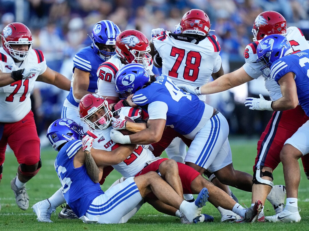 (Francisco Kjolseth | The Salt Lake Tribune) Utah Tech Trailblazers running back Kona Crowell (22) feels the weight of the BYU defense during the first half of an NCAA college football game against Utah Tech, Saturday, Sept. 5, 2026, at LaVell Edwards Stadium in Provo.