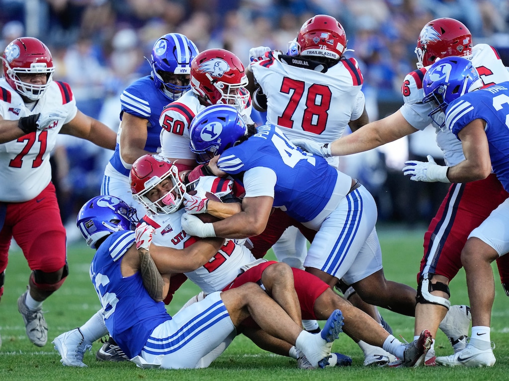 (Francisco Kjolseth | The Salt Lake Tribune) Utah Tech Trailblazers running back Kona Crowell (22) feels the weight of the BYU defense during the first half of an NCAA college football game against Utah Tech, Saturday, Sept. 5, 2026, at LaVell Edwards Stadium in Provo.