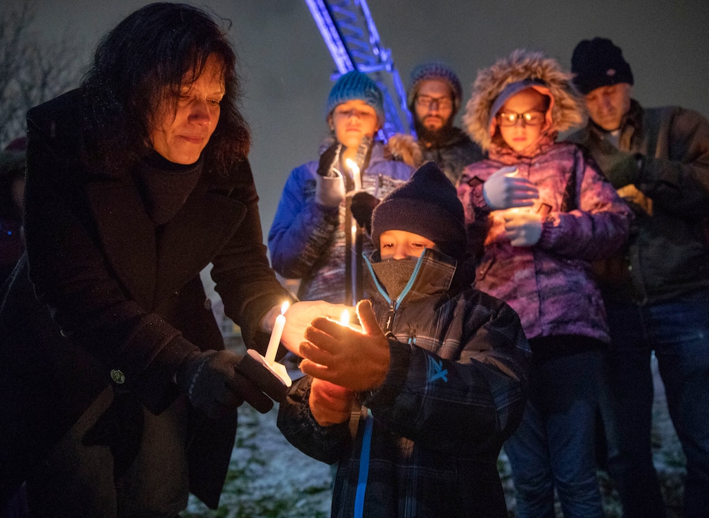 (Keith Johnson | Special to The Tribune) Tiffany VanZeben lights the candle of her grandson Emery Romrell (6) during a candlelight vigil Dec. 2, 2018, at the Columbus Community Center in South Salt Lake for Officer David Romrell, a South Salt Lake police officer killed in the line of duty Nov. 24, when he was struck by a car driven by a fleeing suspect. Several hundred members of the community attended the vigil including family, friends, South Salt Lake Mayor Cherie Wood and representatives from the Utah Highway Patrol, Unified Police and Unified Fire.