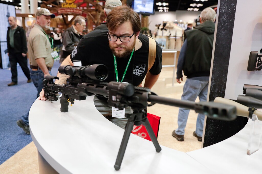 (Michael Conroy | AP file photo) Evan Downey of Gallipolis, Ohio looks over a rifle display in the exhibition hall at the National Rifle Association Annual Meeting in Indianapolis, Saturday, April 27, 2019.