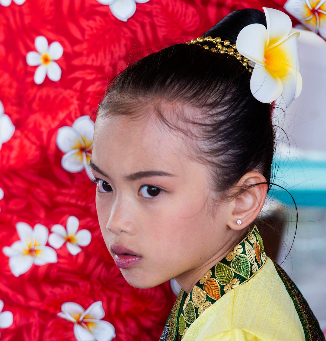 (Rick Egan  |  The Salt Lake Tribune)   Kandra  Konboukay, 7 stands by her mother as she makes a papaya salad, during the Wat Lao Salt Lake Buddharam Utah, New Year Celebration, in West Valley City, Sunday, April 28, 2019.