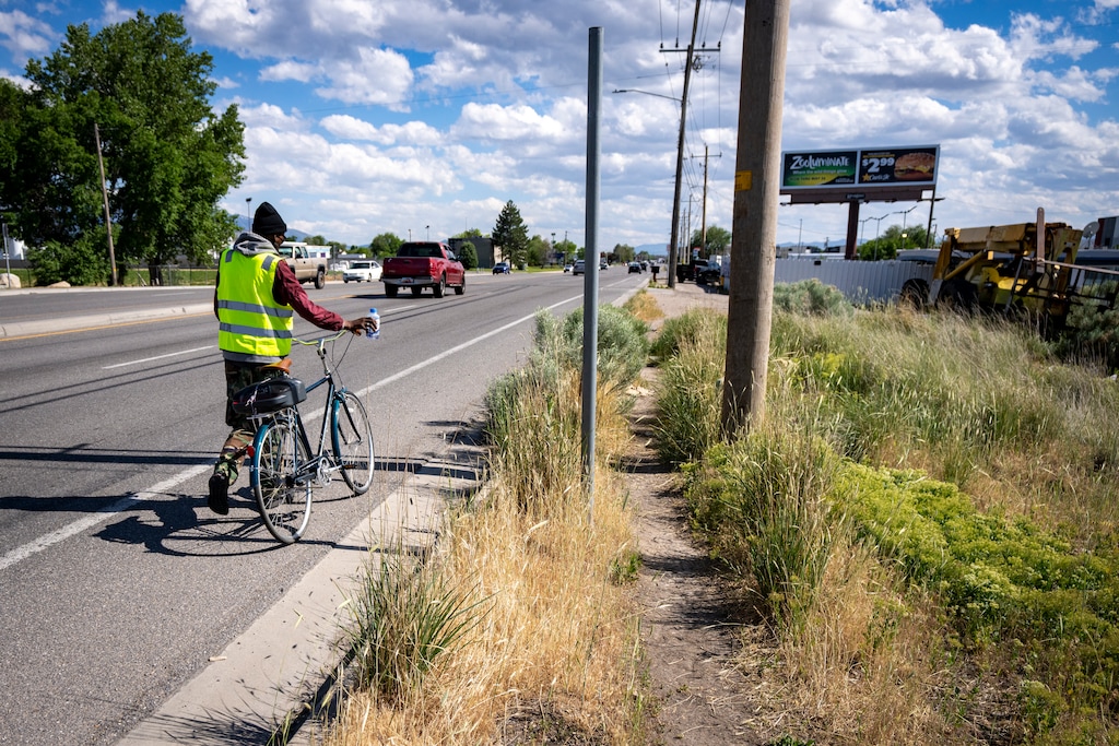 (Rick Egan | The Salt Lake Tribune) A man walks his bike along Redwood Road where there is no sidewalk, near Indiana Ave, on Tuesday, May 20, 2025.