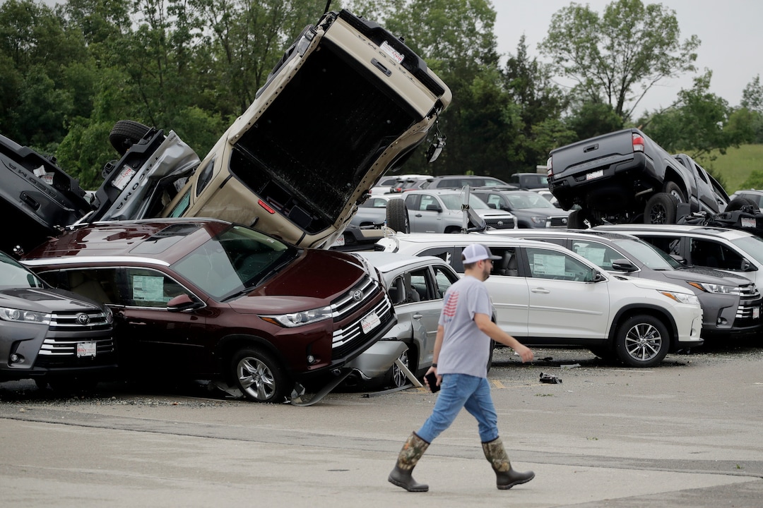(Charlie Riedel |AP) A worker walks past tornado-damaged Toyotas at a dealership in Jefferson City, Mo., Thursday, May 23, 2019, after a tornado tore though late Wednesday.