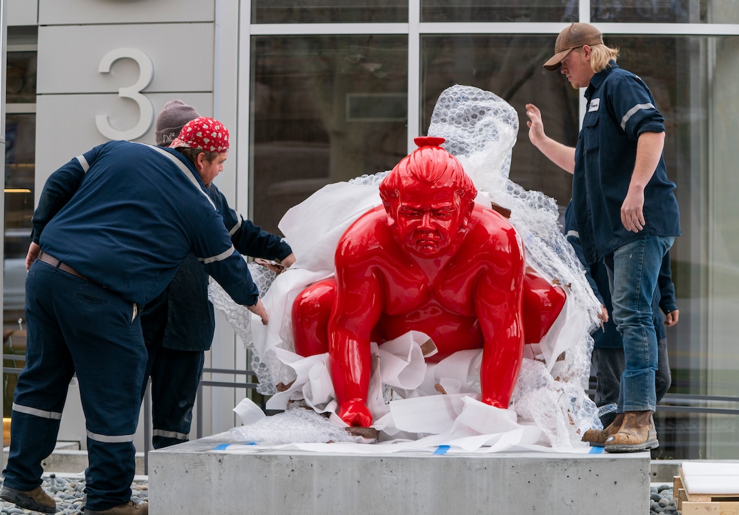 (Rick Egan | The Salt Lake Tribune)  Workers place a new art installation featuring a life-size sumo wrestler, in front of the Mountain West Commercial Real Estate building, previously the KALL Radio 910 broadcast station, on South Temple, in Salt Lake City, on Monday, March 29, 2021