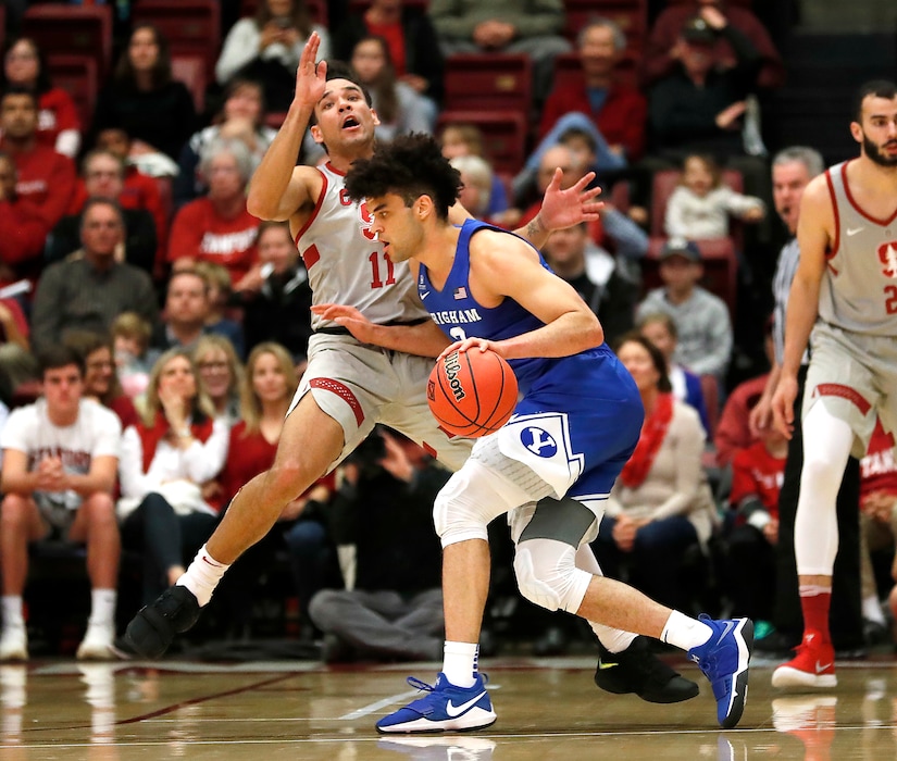 BYU guard Elijah Bryant (3) collides with Stanford guard Dorian Pickens (11) and is called for charging during the first half of an NCAA college basketball game in the first round of the NIT on Wednesday, March 14, 2018, in Stanford, Calif. (AP Photo/Tony Avelar)