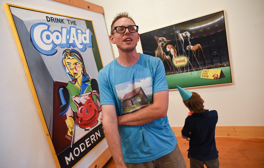 (Francisco Kjolseth  |  The Salt Lake Tribune)  Artist Ben Steele describes some of his paintings as a young visitor takes in the "Dali Art Show," during the monthly gallery stroll in downtown Helper, Utah on Friday, Aug. 2, 2019.