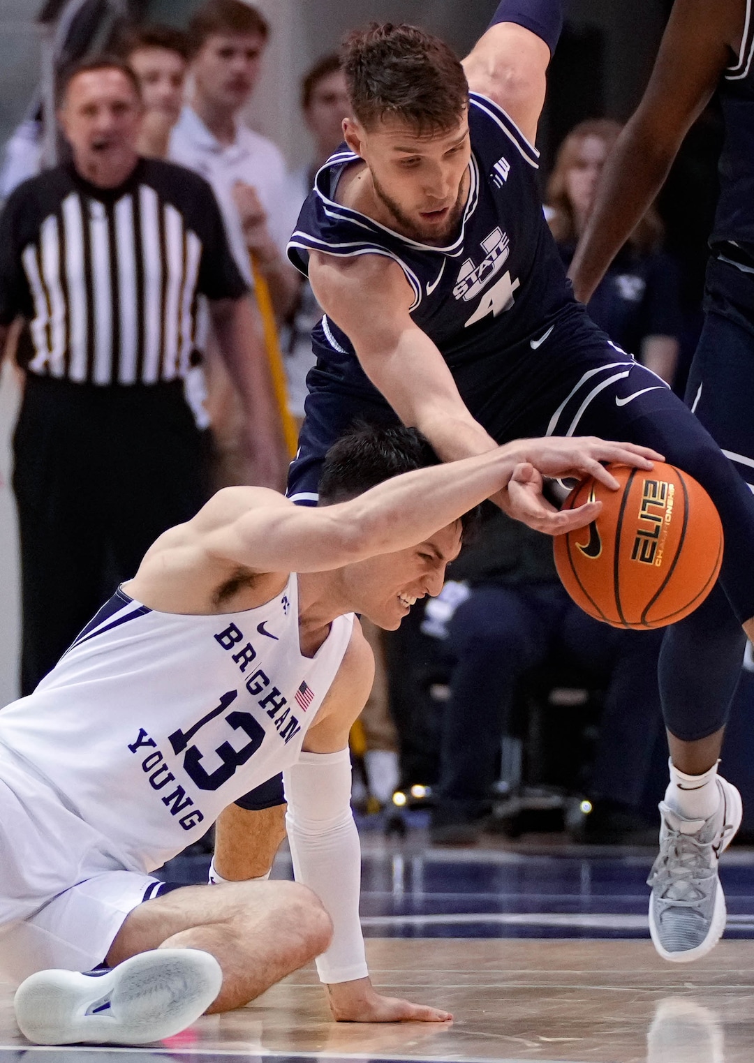 (Francisco Kjolseth | The Salt Lake Tribune) Brigham Young Cougars guard Alex Barcello (13) goes down as Utah State Aggies forward Brandon Horvath (4) moves in basketball action between the Brigham Young Cougars and the Utah State Aggies at the Marriott Center in Provo, Wednesday, Dec. 8, 2021.