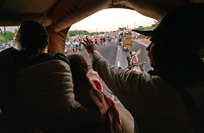 Rick Egan  |  The Salt Lake TribuneTom Whitaker (right) Midway, and his wife Linda (and Aleah (middle) wave to the crowd as the approach the This is the Place monument, at the mouth of Emigration canyon, Tuesday, July 22, 1997.