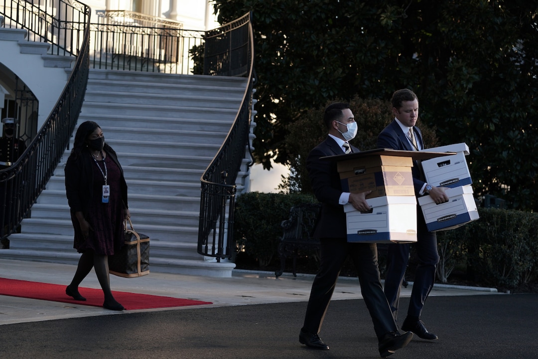 Staff members carry boxes from the White House as President Donald Trump prepares to depart on Wednesday morning, Jan. 20, 2021, hours before the presidential inauguration of Joe Biden. Defeated and twice impeached, the 45th president used his farewell remarks before a sparse crowd to brag about his record and wish luck to the incoming administration. (Anna Moneymaker/The New York Times)