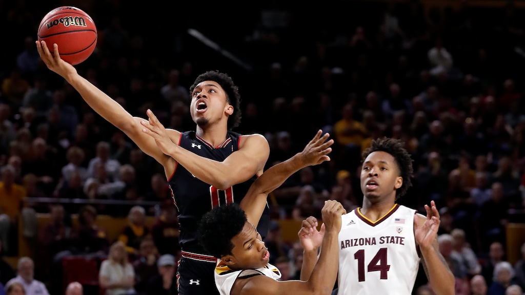 Utah guard Sedrick Barefield (0) shoots as Arizona State forward Kimani Lawrence (14) and Arizona State guard Tra Holder defend during the first half of an NCAA college basketball game, Thursday, Jan. 25, 2018,in Tempe, Ariz. (AP Photo/Matt York)