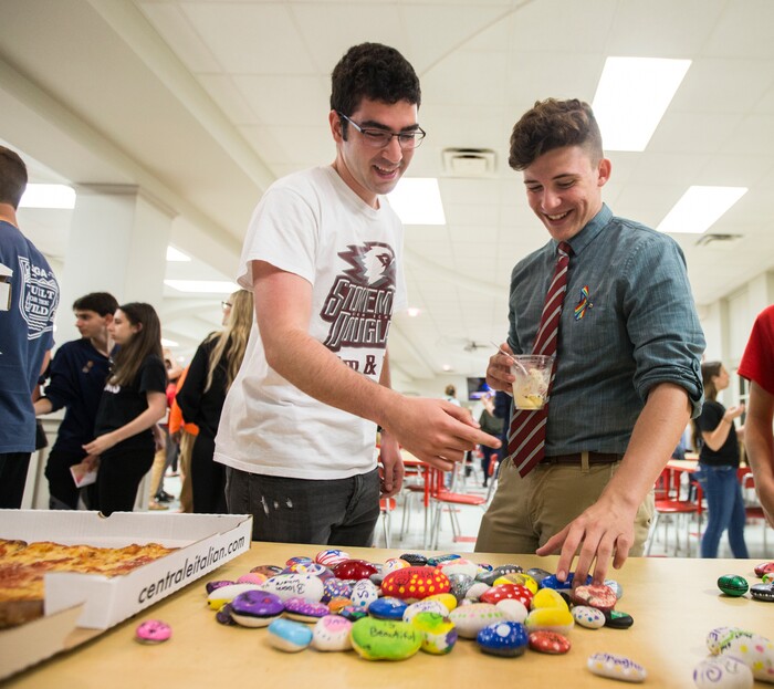 Lorenzo Prado, left, and Alfonso Calderon student survivors from Marjory Stoneman Douglas High School look over some painted rocks made available to them in the cafeteria at Leon High School in Tallahassee, Fla., Tuesday, Feb 20, 2018. Students who survived a Florida school shooting that killed more than a dozen students and faculty and injured others have created the Never Again movement to channel their anger and frustration. The students from Marjory Stoneman Douglas High School are in town to lobby the Florida legislature to stop gun violence after the deadly shooting at their school. (AP Photo/Mark Wallheiser)