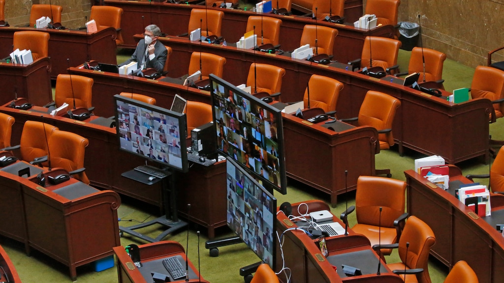 Video monitors are shown in a nearly empty room, during the Utah Legislature's virtual special session from the House chambers at the Utah State Capitol Thursday, April 16, 2020, in Salt Lake City. In a historical, first-ever virtual special session, the Utah House voted to pass several bills seeking to respond to the global coronavirus pandemic. (AP Photo/Rick Bowmer)