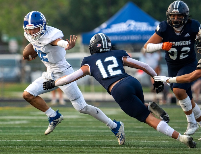 (Rick Egan | The Salt Lake Tribune)  Bingham quarterback Dallen Martinez (12) runs the ball, as Kolbyn Jackson (12) defends for Corner Canyon, in prep football action between the Corner Canyon Chargers and the Bingham Miners, on Friday, Aug. 27, 2021.