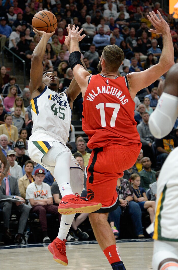 (Francisco Kjolseth  |  The Salt Lake Tribune)  Utah Jazz guard Donovan Mitchell (45) tries to shoot past Toronto Raptors center Jonas Valanciunas (17) in the first half of the preseason NBA game at Vivint Smart Home Arena Tuesday, Oct. 2, 2018, in Salt Lake City.