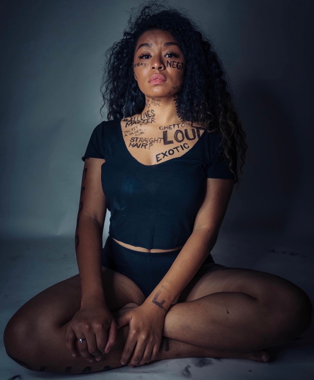(Photo courtesy of Ana Brown Photo + Film) Stephanie Nguyen Lake poses for a photo with negative stereotypes used to describe black women painted on her skin.