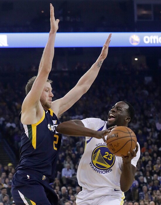 Golden State Warriors forward Draymond Green (23) is defended by Utah Jazz forward Joe Ingles during the first half of an NBA basketball game in Oakland, Calif., Wednesday, Dec. 27, 2017. (AP Photo/Jeff Chiu)