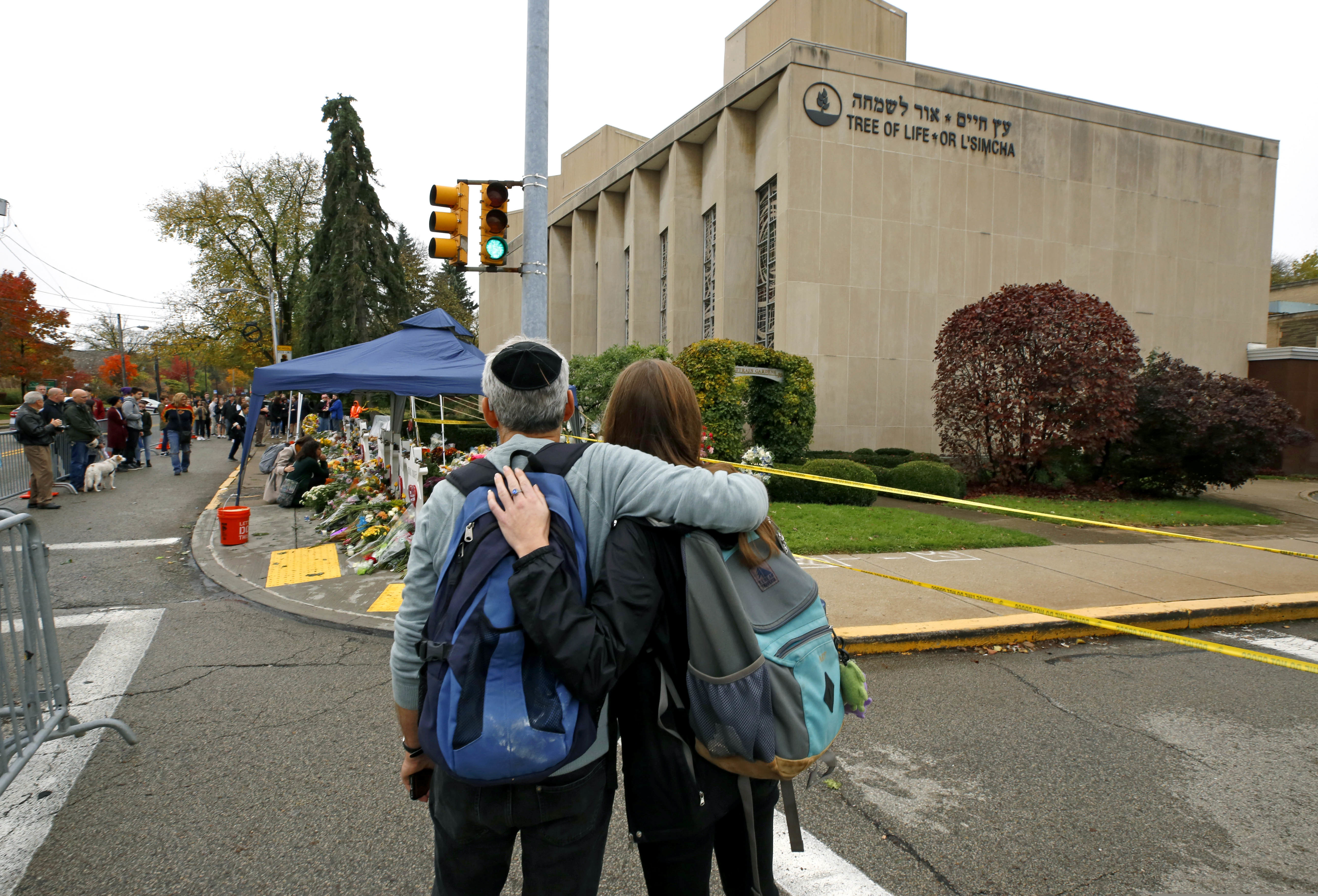 (Gene J. Puskar | AP Photo) In this Nov. 1, 2018, file photo people pay their respects at a makeshift memorial for the 11 people killed while worshipping on Saturday, Oct. 27 at the Tree of Life synagogue in the Squirrel Hill neighborhood of Pittsburgh.