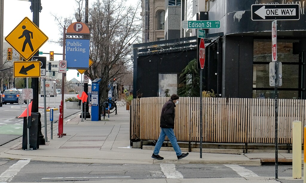 (Francisco Kjolseth  |  The Salt Lake Tribune) A lone pedestrian wears a mask as he walks the mostly empty streets of downtown Salt Lake City as most people shelter at home during the coronavirus (COVID-19) pandemic on Thursday, March 26, 2020.