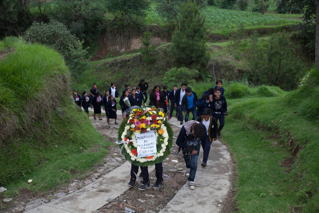 (AP Photo/Moises Castillo) School children carry a crown of flowers for Claudia Gomez Gonzalez a Guatemalan immigrant who was fatally shot by a U.S. Border Patrol agent in Texas, during the second day of her wake, in San Juan Ostuncalco, Guatemala, Friday, June 1, 2018. The young woman, who was fatally shot by a U.S. Border Patrol agent in Texas on May 23, had graduated as a forensic accountant but was unable to attend college or find a job, so she had left Guatemala for the U.S., according to her aunt.