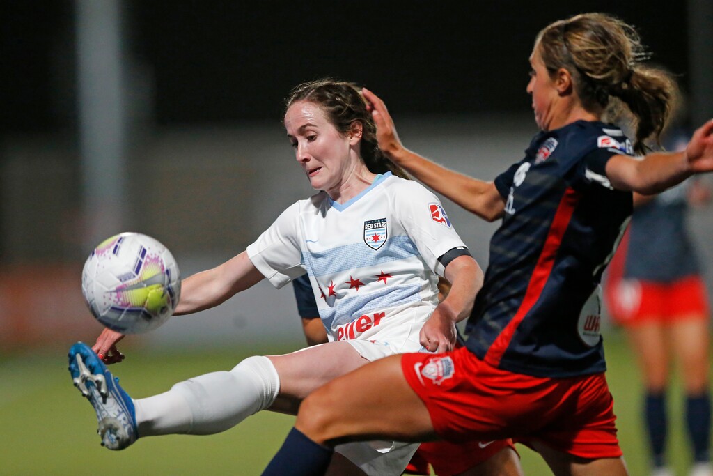 Chicago Red Stars' Michele Vasconcelos kicks the ball as Washington Spirit forward Jordan Dibiasi, right, defends during the second half of an NWSL Challenge Cup soccer match at Zions Bank Stadium, Saturday, June 27, 2020, in Herriman, Utah. (AP Photo/Rick Bowmer)