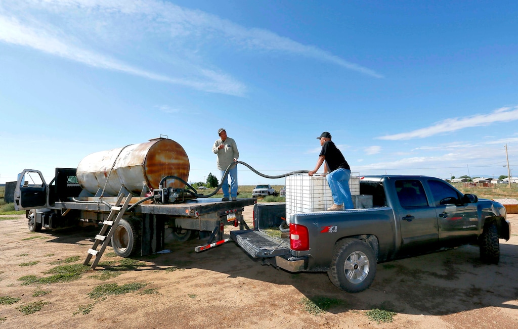 (Matt York | The Associated Press) Melvin Jones, left, delivers water to rancher Timothy Curley along the San Juan River on the Navajo Reservation, Wednesday, Aug. 12, 2015, in Shiprock, NM. Toxic wastewater from the Gold King Mine in Silverton, Colo., has contaminated the San Juan River in Northern New Mexico from the runoff of the Animas River due to an accidental breach by a mining a safety team working for the Environmental Protection Agency last week. A 100-mile-long plume has since traveled for hundreds of miles, through parts of Colorado, New Mexico and Utah on the way to Lake Powell, a key source of water for the Southwest.