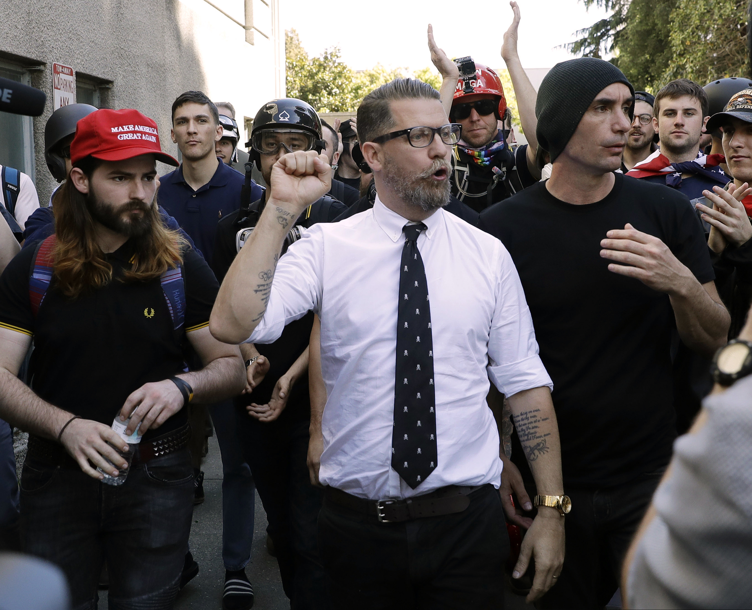 FILE - In this April 27, 2017 file photo, Gavin McInnes, center, founder of the far-right group Proud Boys, is surrounded by supporters after speaking at a rally in Berkeley, Calif. (AP Photo/Marcio Jose Sanchez, File)