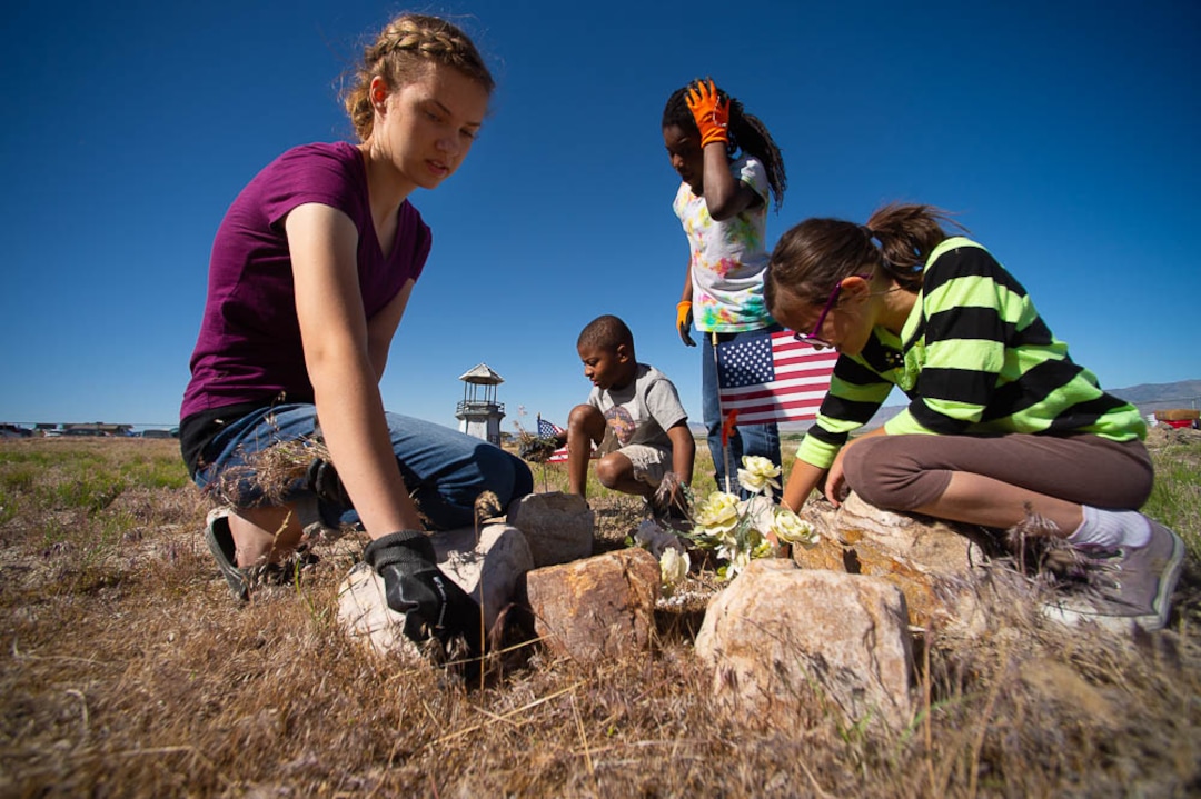 (Trent Nelson | The Salt Lake Tribune)  Descendants of the Hawaiians who settled the desert town of Iosepa took time during their Memorial Day gathering to clean the graves of their ancestors, Saturday May 26, 2018. Lynnea Crook, Garrett Crook, Sariah Crook, and Evaine Ha'o pull weeds from around a grave