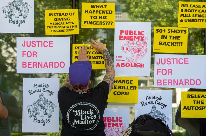 (Rick Egan  |  The Salt Lake Tribune) Protesters put up posters at the Salt Lake District Attorney's Office in Salt Lake City during a demonstration for Bernardo Palacios, Monday, June 22, 2020.