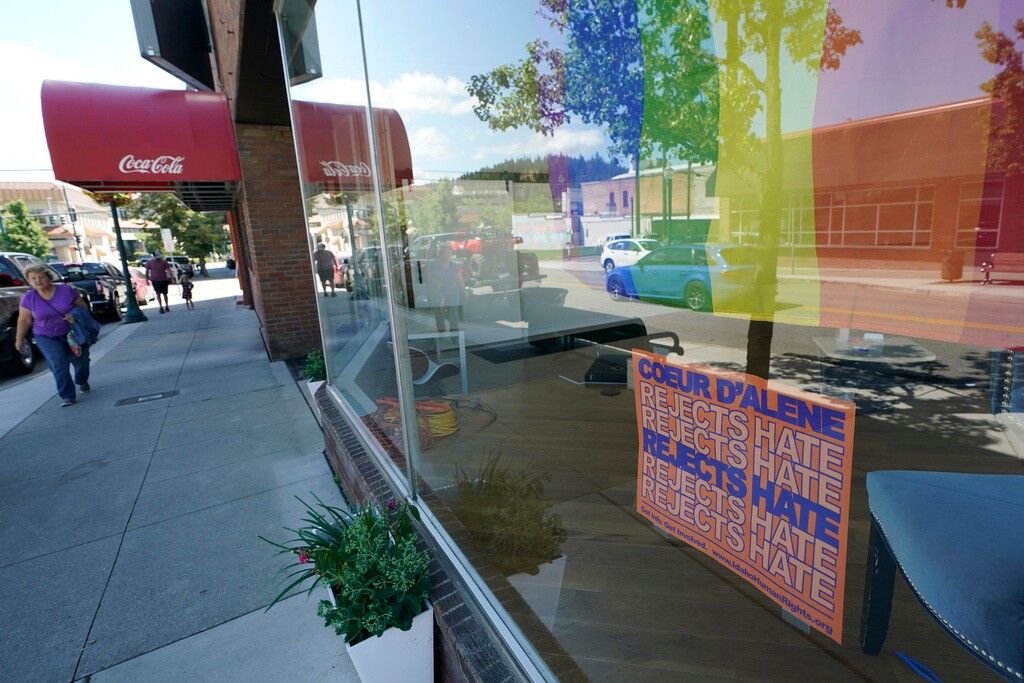 (Ted S. Warren | AP file photo) A sign that reads "Coeur d'Alene Rejects Hate" is shown under a pride flag in the window of the Emerge CDA art gallery, July 18, 2022, in downtown Coeur d'Alene, Idaho. A northern Idaho jury on Thursday, July 20, 2023, found five members of the white nationalist hate group Patriot Front guilty of misdemeanor charges of conspiracy to riot at a Pride event.