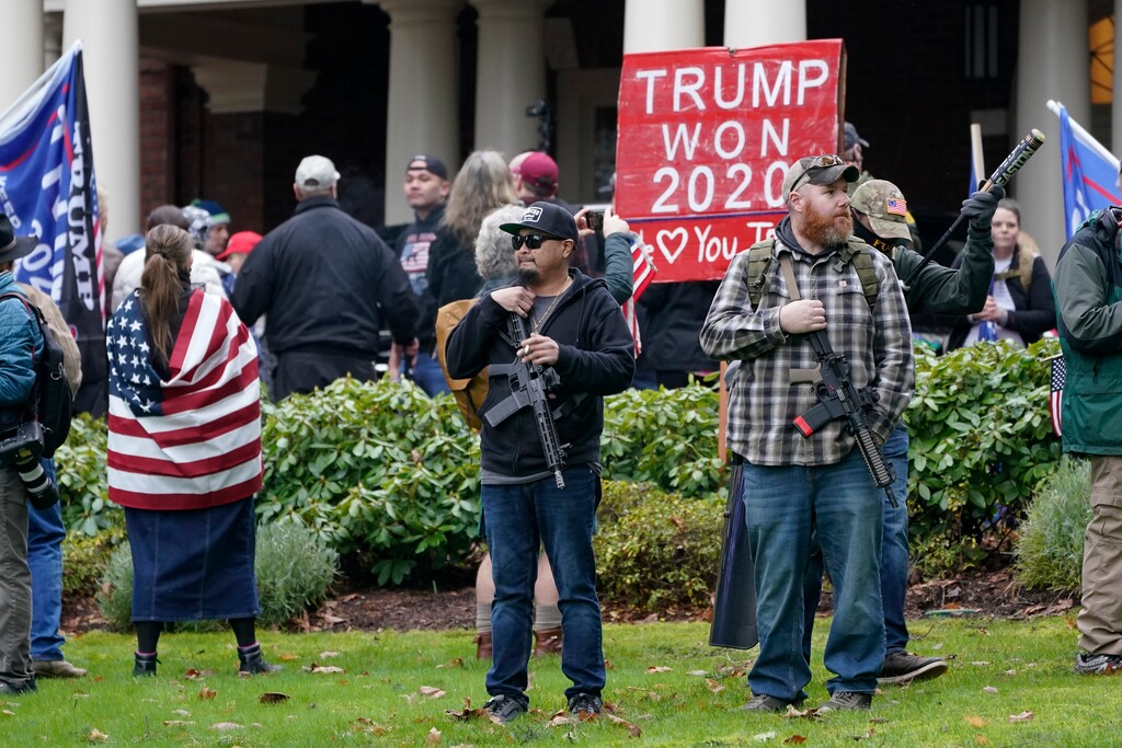 (Ted S. Warren | AP photo)
In this Jan. 6 photo, two men stand armed with guns in front of the Governor's Mansion in Olympia, Wash., during a protest supporting President Donald Trump and against the counting of electoral votes in Washington, D.C., affirming President-elect Joe Biden's victory.